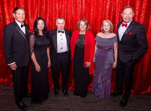 Group photo of three smiling couples in formal wear.